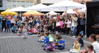 Kinder und Erwachsene rumwuselnd auf dem Marktplatz, Quelle: DTF