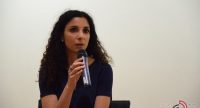 Frau in schwarzer Bluse spricht ins Mikrofon, Quelle: DTF
