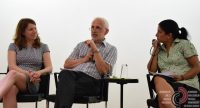 zwei Frauen und ein Mann sitzend auf der Bühne, der Mann spricht, die Frauen schauen ihm zu, Quelle: DTF