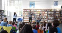 zwei junge Männer und ein Mädchen vor sitzendem Publikum, Quelle: DTF