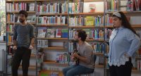zwei junge Männer und ein Mädchen vor sitzendem Publikum, Quelle: DTF