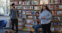 zwei junge Männer und ein Mädchen vor sitzendem Publikum, Quelle: DTF
