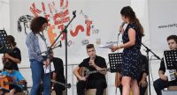sitzende Band auf der Bühne vor Banner des Kinderfests, Quelle: DTF