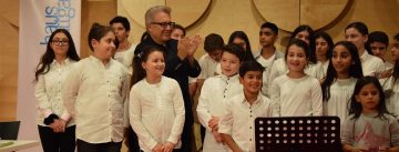 Autor mit Kinderchor in weißen Hemden