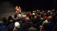 zwei sprechende Frauen auf der Bühne vor vollen Sitzreihen, Quelle: DTF