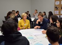 Teilnehmer*innen sitzen um einen Workshoptisch und diskutieren, Quelle: DTF