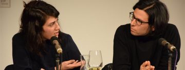 Autor und Autorin schauen sich beim Reden an, ein halb ausgetrunkenes Weinglas steht zwischen ihnen