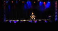 Mann im schwarzen T-Shirt auf einem Rollstuhl mit Silhouette des Publikums im Bildvordergrund, Quelle: DTF