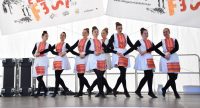 Frauen in traditioneller Kleidung tanzend auf weißer Bühne, Quelle: DTF