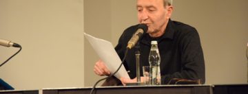 Autor liest von einem Blätterstapel ab