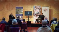zwei Männer sitzen auf Sesseln am Podium, Quelle: DTF
