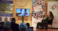 Frauen auf dem Podium mit Bildschirm der Live-Übertragung eines Mannes, Quelle: DTF