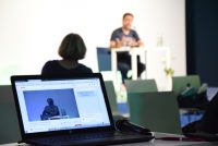 Quelle: DTF Hasnain Kazim sitzend auf dem Podium vor Silhouette des Publikums, Quelle: DTF