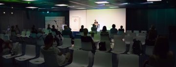 Hasnain Kazim sitzend auf dem Podium vor Silhouette des Publikums