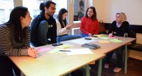 fünf Workshopteilnehmende sitzen an einem langen Tisch und unterhalten sich, Quelle: DTF