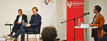 Kandidat*innen auf dem Podium vor interessiertem Publikum