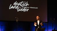 Ein Mann spricht auf der Bühne, Quelle: DTF Stuttgart, Fotograf/in: Özlem Yavuz