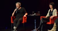 Zwei Personen sitzen in roten Sesseln und lachen., Quelle: DTF Stuttgart