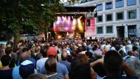 Menschenmasse auf dem Marktplatz schaut auf die Bühne, wo ein Konzert gespielt wird., Quelle: DTF Stuttgart, Fotograf/in: Kerim Arpad