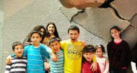 Gruppenbild von fröhlichen Kindern vor einem Dinosaurierkopf, Quelle: DTF