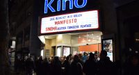 Menschenmenge, die abends vor dem Kino steht. Beleuchtete Kinotafel mit den aktuellen Filmen ist zu sehen., Quelle: DTF Stuttgart