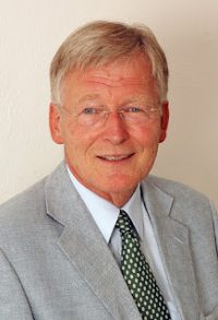 freundlich lächelnder Mann in grauem Anzug mit grüner Krawatte, Quelle: DTF