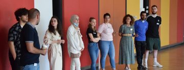 Gruppenbild mit jungen Menschen, die an einer Wand nebeneinander stehen