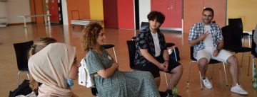 Junge Frauen und Männer im Stuhlkreis