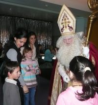 Frauen und Kinder rund um Mann im Nikolauskostüm, Quelle: DTF