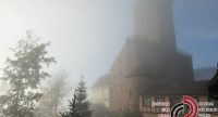 Burg im Nebel, in der linken oberen Bildecke ist ein Regenbogen zu erahnen, Quelle: DTF