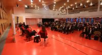 Podiumsgespräch von schräg hinten fotofrafiert mit Publikum in großem Saal, Quelle: DTF