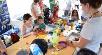 Kinder sitzen um einen Tisch und malen, Quelle: DTF