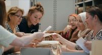 Mehrere Frauen lesen über einen Tisch gebeugt Briefe, Quelle: inselfilm produktion