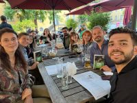 Quelle: DTF Stuttgart Eine Gruppe von Menschen sitzt an einem Tisch und hält Bücher in den Händen, Quelle: DTF Stuttgart